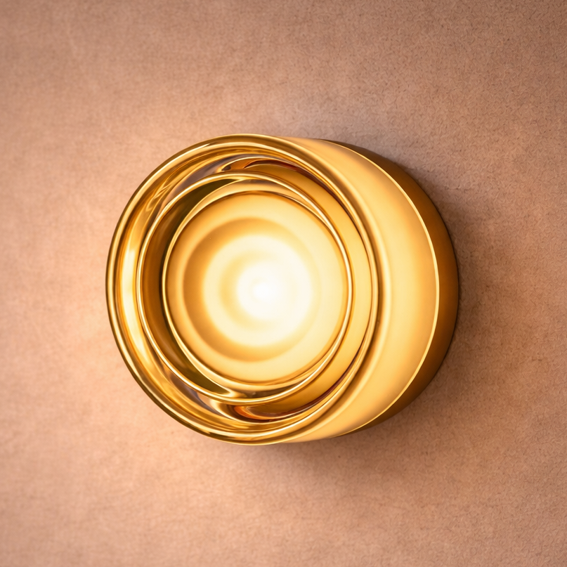 Gold wall sconce on a beige wall