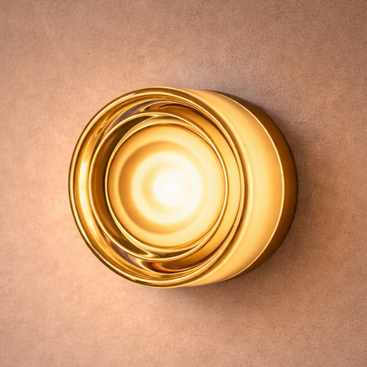 Gold wall sconce on a beige wall